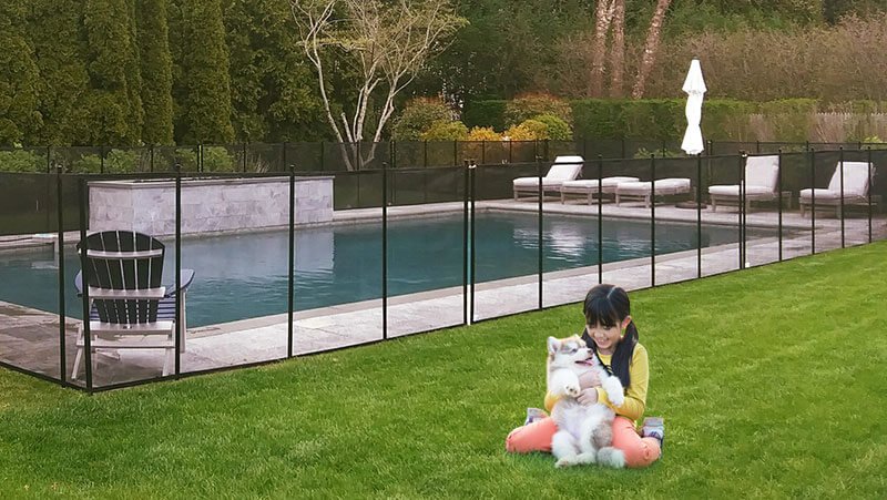 girl and dog sitting outside a pool with BABY-LOC removable pool fencing